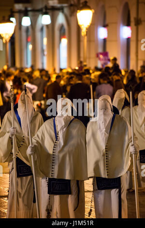 TARANTO, ITALIE - 13-14 avril 2017 : chaque année, les rites de Pâques aura lieu à Tarente. Le Jeudi saint et le vendredi, les membres des fraternités s'habillent de robes blanches, couvrant leurs visages avec les capots avec seulement deux fentes pour les yeux, qui les rendent méconnaissables. À la suite d'une ancienne route à travers la ville, des fraternités marcher pieds nus, portant la lourde statues représentant le chemin de croix jusqu'à l'aube. Banque D'Images