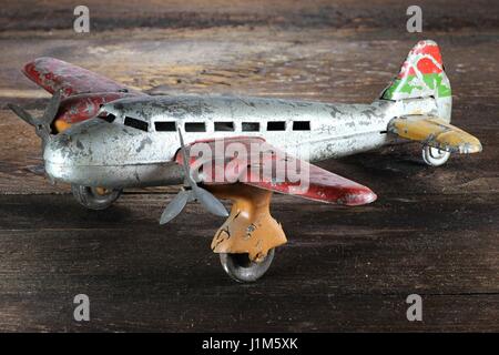 Avion jouet étain antique sur fond de bois Banque D'Images