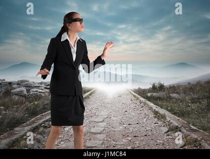 Digital composite of business woman walking down road les yeux bandés Banque D'Images