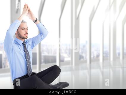 L'homme d'affaires avec les mains sur la tête de méditer avec poussée contre la fenêtre blanche floue Banque D'Images