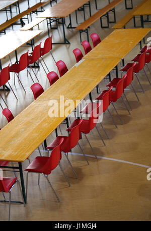 De nombreux longue table avec des chaises rouges dans une grande classe Banque D'Images