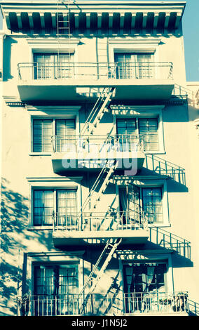 Image style rétro avec bâtiment de quatre étages avec des ombres de la vieille ville caractéristique d'échelles d'évacuation de la connexion d'un balcon au sol San Franc Banque D'Images