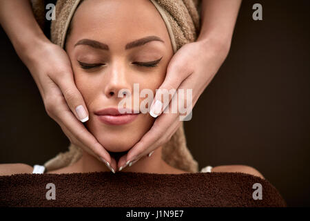 Belle jeune femme bénéficiant au cours de massage du visage en beauté close up Banque D'Images