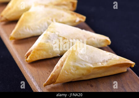 Un lot de spanakopita grecs cuits en format triangle Banque D'Images