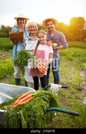 Heureux famille rurale avec des légumes produits dans le champ Banque D'Images