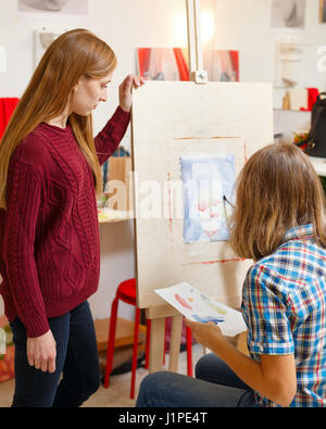 Des cours en école d'art. L'enseignant observe l'élève. Girl attire l'Nature morte avec l'aquarelle. Des cours de dessin pour adultes. Banque D'Images