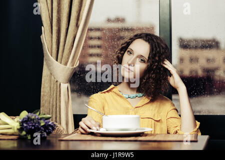 Jeune femme de manger une soupe au restaurant Banque D'Images