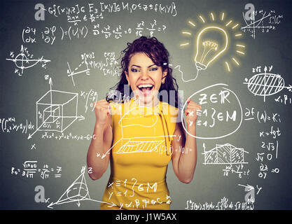 Smart excited woman student avec idée lumineuse ampoule et mathématiques et sciences des formules sur fond noir Banque D'Images