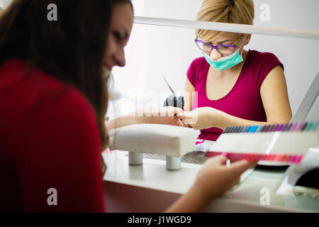 Femme au salon de manucure et de recevoir un traitement d'ongle Banque D'Images
