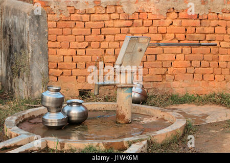 Ancienne pompe à eau à main et récipients de l'eau dans les régions rurales de l'Inde Banque D'Images