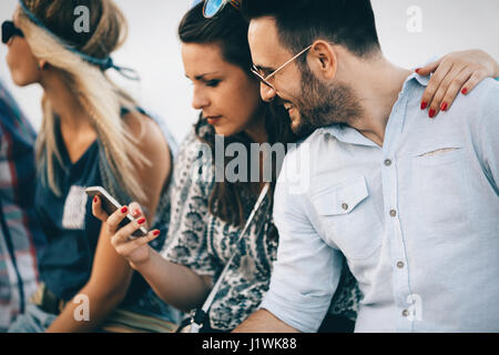 Les jeunes à l'aide de téléphones cellulaires pour le surf et le chat Banque D'Images