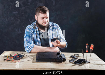 Ingénieur informatique mâle problème fixation avec ordinateur portable. La technologie de la réparation d'appareils électroniques Banque D'Images