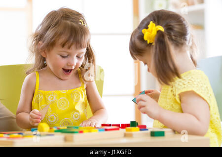 Les enfants jouent avec des jouets de bloc. Deux enfants filles à la maison ou de garderie. Jouets éducatifs pour enfants d'âge préscolaire et de la maternelle. Banque D'Images