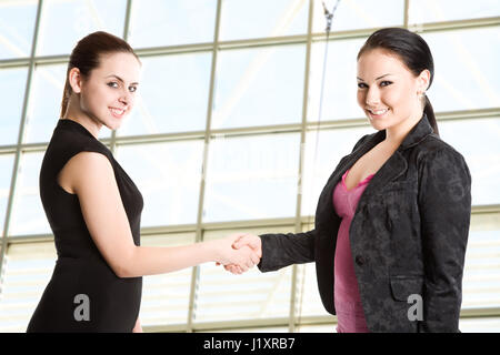 Two businesswomen shaking hands au bureau Banque D'Images