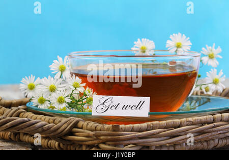 Carte de prompt avec tasse de thé et camomille fleurs sur fond bleu Banque D'Images