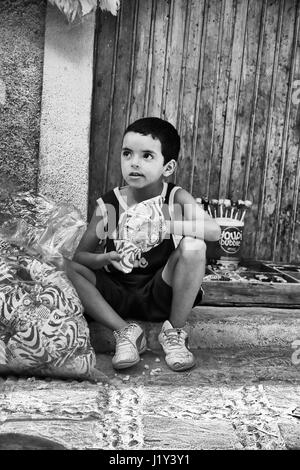 Morrocan boy vente de bonbons dans une rue à Chefchaouen, Maroc Banque D'Images