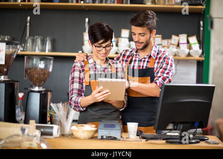 Propriétaires souriants sur commande tablet Banque D'Images