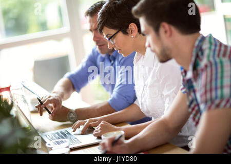 Les gens d'affaires travailler sur ordinateur portable in coffee shop Banque D'Images