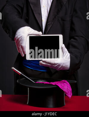 Magicien holding tablet pc sur ses accessoires pour travailler, de la publicité et de l'illusion Banque D'Images