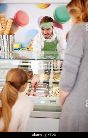 Travailleur en pâtisserie servant girl with ice cream Banque D'Images