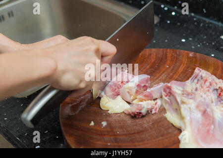 Dame hacher le poulet sur une carte chop en bois Banque D'Images