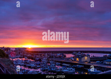 L'Angleterre, port de Ramsgate. Lever de soleil sur la manche. Le port de Ramsgate de premier plan. Petite Bande d'open orange ciel avec lever de soleil, au-dessus de ce nuage mauve en couches épaisses. Banque D'Images