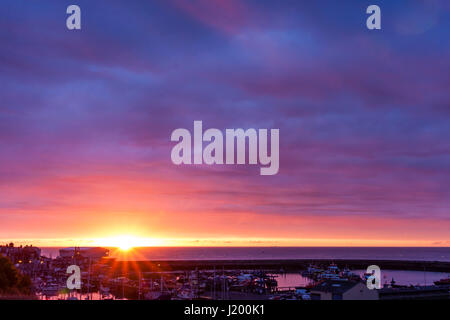 L'Angleterre, port de Ramsgate. Lever de soleil sur la manche. Le port de Ramsgate de premier plan. Petite Bande d'open orange ciel avec lever de soleil, au-dessus de ce nuage mauve en couches épaisses. Banque D'Images