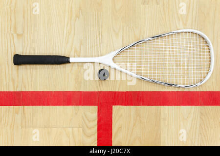 Raquette de Squash blanc et la balle sur le plancher en bois Vue de dessus. L'équipement sur la cour de racquetball près de red line Banque D'Images