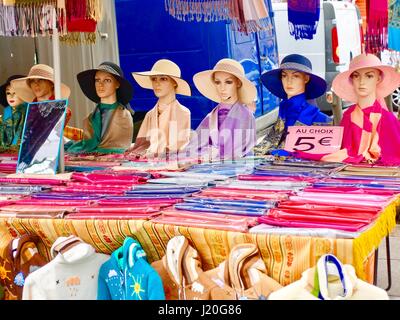 Sept mannnequins portant des chapeaux aux couleurs vives, plus, bien plié, foulards de couleur en vente sur un stand, dimanche marché Bastille, Paris, France. Banque D'Images