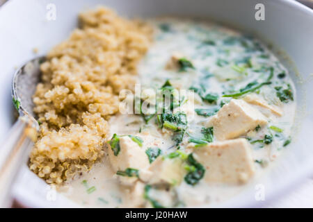 Gros plan macro de tofu curry vert avec le quinoa dans un bol Banque D'Images