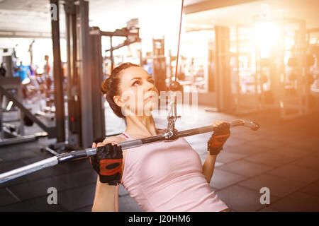 Jeune femme de remise en forme à proximité de la scène grip lat pulldown sur machine de câble Banque D'Images