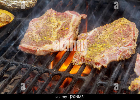 Les steaks sur le gril biftecks de new york avec des flammes Banque D'Images
