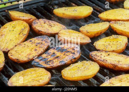 Les pommes de terre, et de la viande sur les brochettes grillées barbecue BBQ chaud sur des pommes de terre grillées Banque D'Images