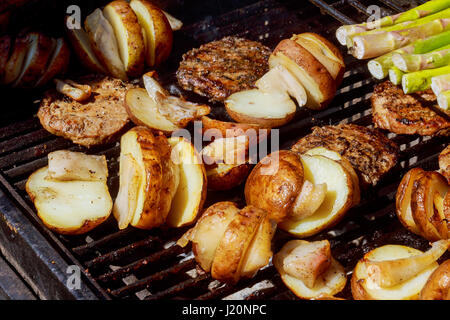 Les pommes de terre, et de la viande sur les brochettes grillées barbecue BBQ chaud sur des pommes de terre grillées Banque D'Images