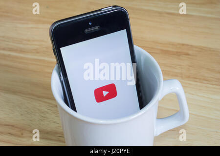 Bangkok, Thaïlande - 22 Avril 2017 : Apple iPhone5s dans un mug montrant l'écran avec le logo Youtube. Banque D'Images