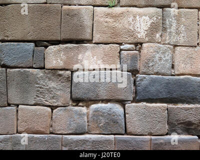 Mur Inca faite de pierres volcaniques naturelles, parfaitement en forme, héritage de l'histoire et l'architecture Inca à Cusco, Pérou. Banque D'Images