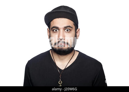 Portrait de jeune homme malheureux surpris choqué avec t-shirt noir et le chapeau à la recherche à l'appareil photo. studio shot, isolé sur fond blanc. Banque D'Images