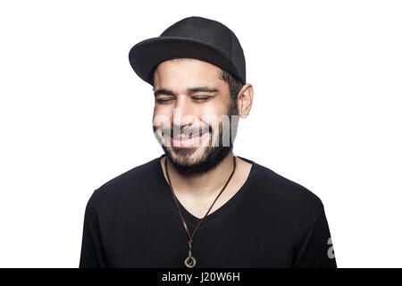 Portrait de jeune homme smilely heureux avec t-shirt noir et le chapeau avec les yeux fermés et sourire à pleines dents. studio shot, isolé sur fond blanc. Banque D'Images