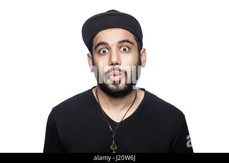 Portrait de jeune homme malheureux surpris choqué avec t-shirt noir et le chapeau à la recherche à l'appareil photo. studio shot, isolé sur fond blanc. Banque D'Images