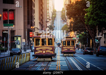 La vue classique du câble traditionnel historique voitures rouler sur la célèbre rue de la Californie dans la belle lumière du matin au lever du soleil, San Francisco, États-Unis Banque D'Images