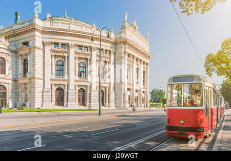 La vue classique du célèbre Ringstrasse Wiener Burgtheater et historique avec le tramway électrique rouge traditionnelle sur une belle journée ensoleillée à Vienne, Autriche Banque D'Images