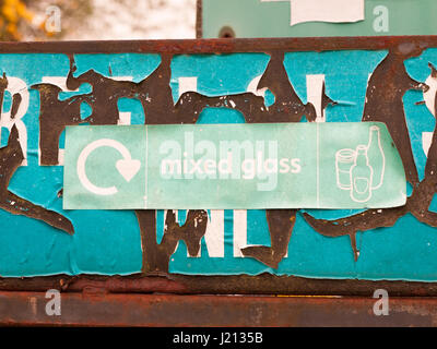 Un signe de recyclage vert près de l'usine de recyclage de verre et bacs de verre mixte dit avec des photos de verres et bouteilles environnement propre Banque D'Images