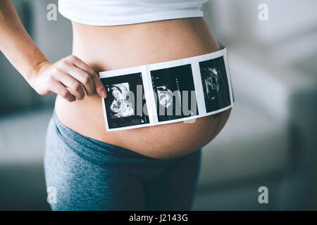 Beautiful pregnant woman holding ultrasound scan sur ventre Banque D'Images