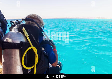 Femme avec l'équipement de plongée à la recherche à la mer. Banque D'Images