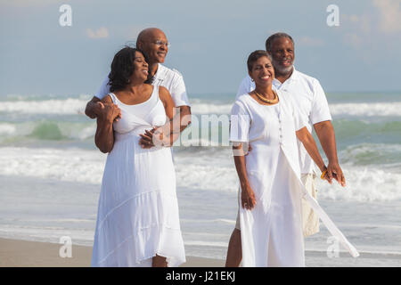Happy senior African American les hommes et les femmes des couples marchant sur une plage tropicale déserte Banque D'Images
