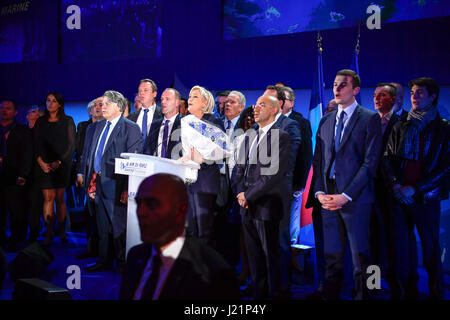 Henin-Beaumont, France. 23 avril, 2017. Marine Le Pen (C), l'extrême droite Front National (FN), candidat à la présidentielle, chante l'hymne national français lors d'un rassemblement après le premier tour de l'élection présidentielle française, à Henin-Beaumont, France le 23 avril 2017. Candidat centriste et ancien ministre de l'économie Emmanuel Macron et candidat d'extrême-droite Marine Le Pen le dimanche est arrivé en tête au premier tour de l'élection présidentielle française, selon les prévisions des organismes de sondage et des résultats partiels. Source : Xinhua/Alamy Live News Banque D'Images