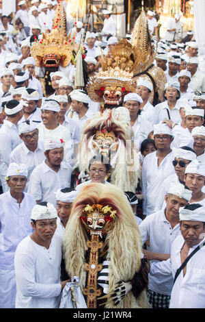 Kesiman, Denpasar, Bali, Indonésie. Apr 23, 2017. Grand rassemblement d'hommes balinais habillés en vêtements de cérémonie dans un temple hindou de participer à la cérémonie d'Pengerebongan. Ce rituel a lieu tous les 210 jours sur le calendrier Saka hindous balinais et entraîne le rituel de Sakral. Après les prières et les offrandes d'un défilé de personnages mythologiques et les hommes et les femmes en transe le tour du temple extérieur terrain avec certains hommes d'essayer de percer la peau avec une traditionnelle Keris (couteau), heureusement, personne n'est blessé lors de cette incroyable cérémonie balinaise au Temple Pura Petilan, Denpasar, Indon Banque D'Images