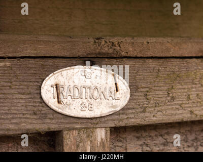 Un metal sign agrafée à une clôture traditionnelle disant brillant ovale vintage rétro à la lumière d'arrière-plan en bois isolé macro détail Banque D'Images