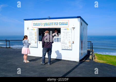 Un homme d'acheter une glace pour une jeune fille à Trillo's ice cream hut sur la falaise ouest de Whitby Banque D'Images