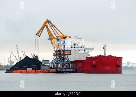 Grand cargo rouge avec un chargement de charbon dans le port Banque D'Images